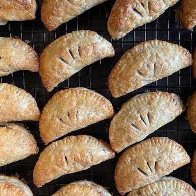 Rows of golden hand pies on a cooling rack